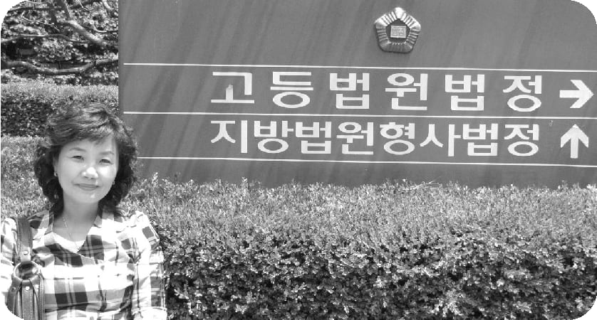 법원 안내 표지판 앞에 서 있는 상담활동가